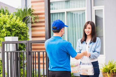 Man giving parcel to woman