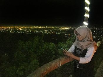 Portrait of man using mobile phone at night