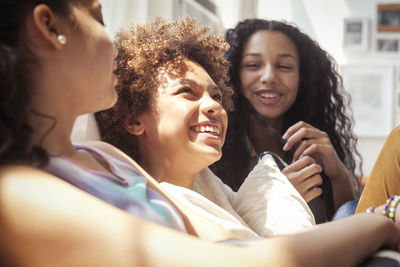 Happy siblings sitting on sofa at home