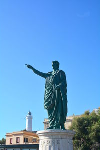 Low angle view of angel statue against clear blue sky