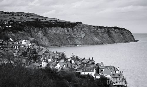 Residential district by sea against sky