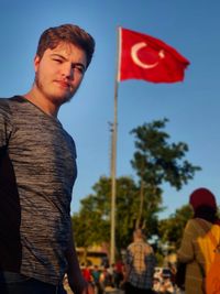 Portrait of young man standing against clear sky