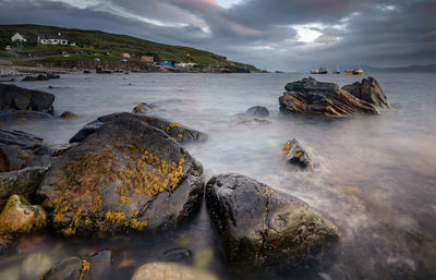 Scenic view of rocks in sea against sky