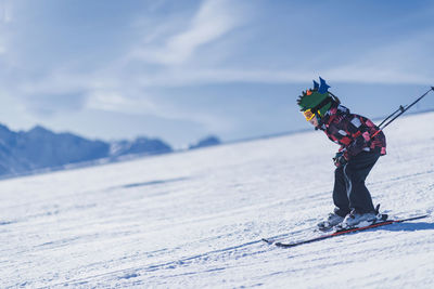 Boy skiing on snowcapped mountain