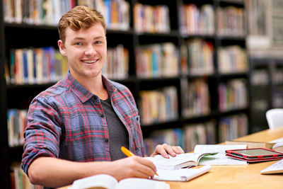 Portrait of smiling man sitting at library