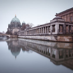 Berlin cathedral by spree river against sky in city