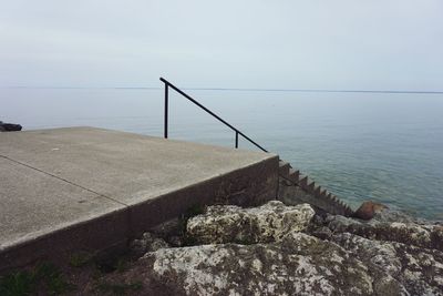 View of swimming pool by sea against sky