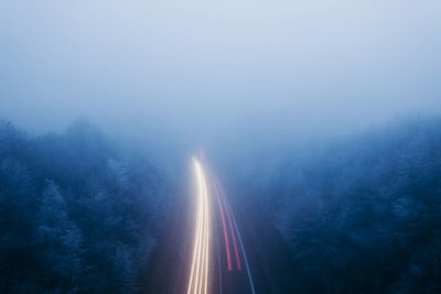 High angle view of road amidst trees against sky