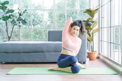 Full length of woman sitting by window