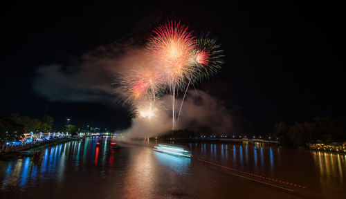 Firework display over river at night