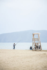 Man standing on beach against clear sky