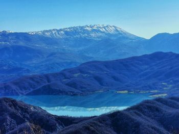 Scenic view of snowcapped mountains against blue sky