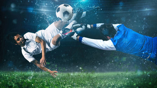 Men playing with soccer ball in grass