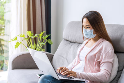 Woman sitting on sofa at home