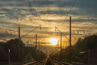 Railroad tracks against sky during sunset