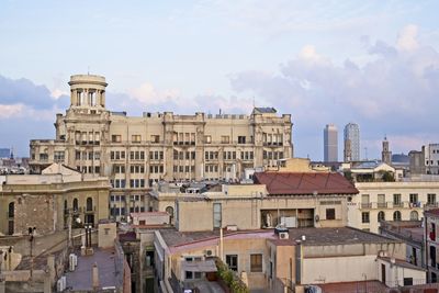 Buildings in city against cloudy sky