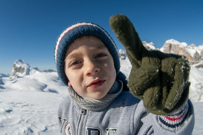 Portrait of smiling young woman against snow