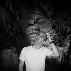 Confused man scratching head in cave