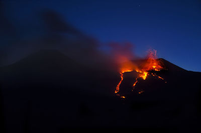 Silhouette mt etna against sky at night