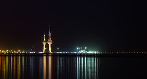 Illuminated buildings by sea at night