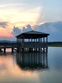 Pier over lake against sky during sunset