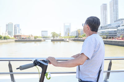 Side view of young man riding bicycle on street in city