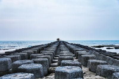 Groyne at beach against sky