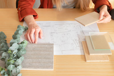 View of woman touching compotition of different materials in interior design