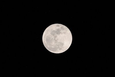 Low angle view of full moon against clear sky at night