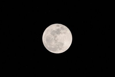 Low angle view of full moon against clear sky at night