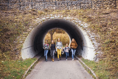 Explorers walking through underpass at countryside