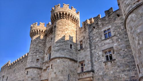 Low angle view of historic building against blue sky