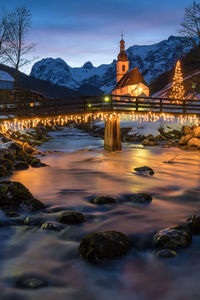 Illuminated buildings against sky during winter