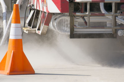 Traffic cone and machinery on road at construction site