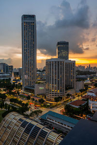 Buildings in city against sky during sunset
