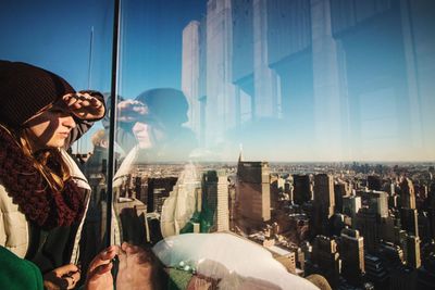 Panoramic view of buildings against sky seen through glass window