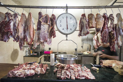 Meat and scale hanging on display at market butcher shop.