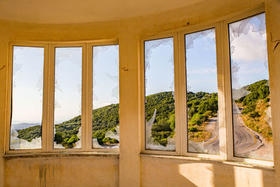 Windows with broken glass view from inside one of the houses on the island of kerkyra corfu greece