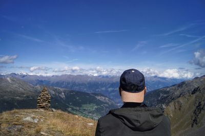 Rear view of man standing on mountain against sky