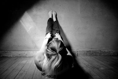 High angle view of woman sitting on floor against wall