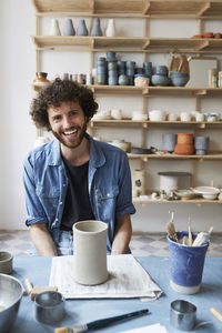 Portrait of smiling man sitting in pottery class