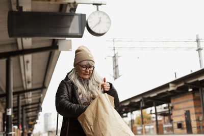 Mature woman at train station