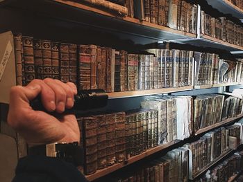 Cropped hand holding flashlight in library