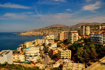 High angle view of townscape by sea against sky