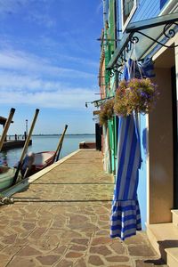 Clothes drying by sea against blue sky