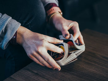 Midsection of man holding camera on table