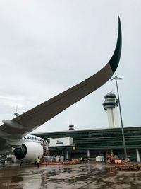 Airplane on airport runway against sky