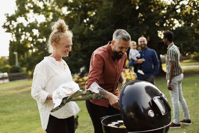 Friends having barbecue in park