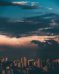 Aerial view of buildings in city at sunset