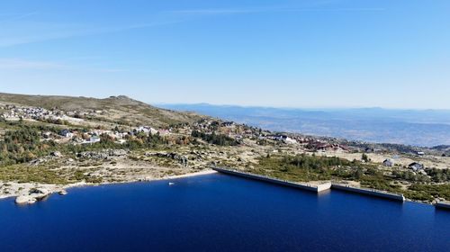 Aerial view of city and mountains against blue sky